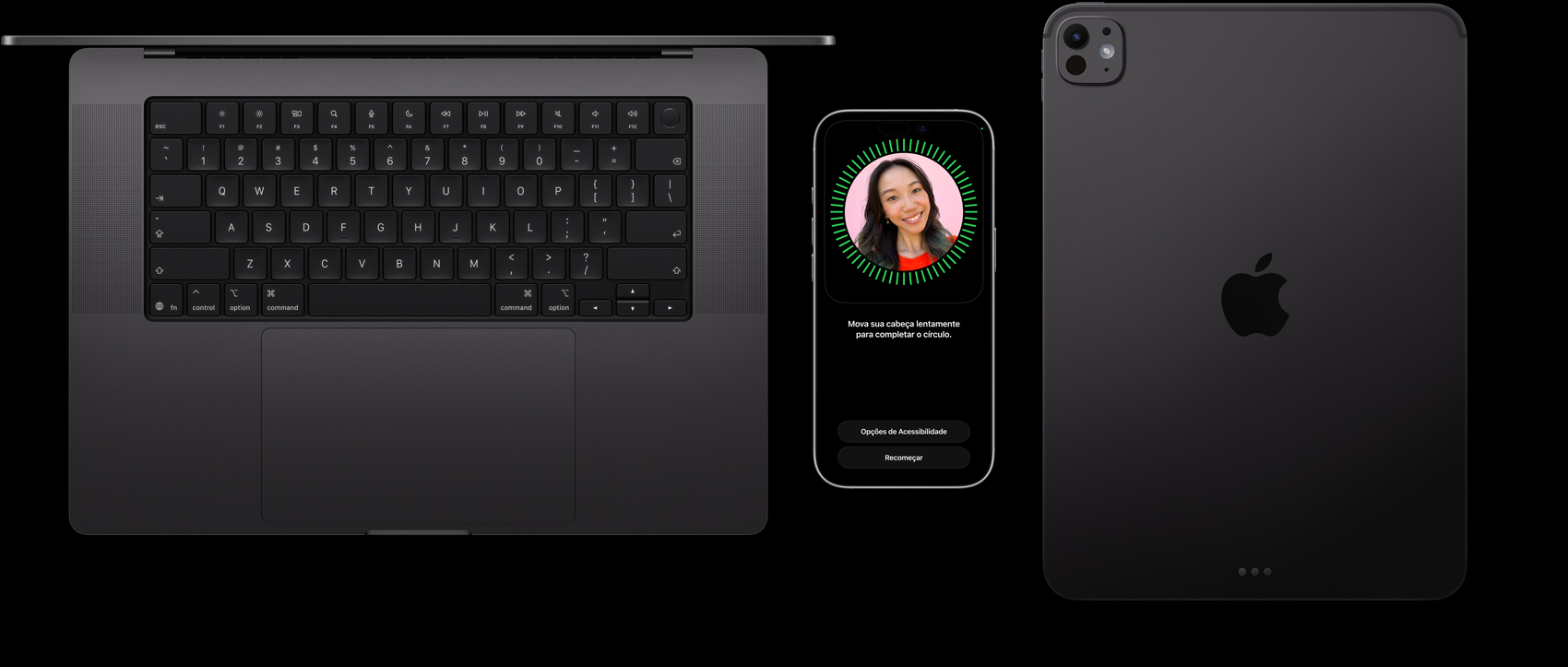 Um MacBook preto-espacial, um iPhone em titânio natural e um iPad preto-espacial, lado a lado, com o Face ID sendo configurado no iPhone