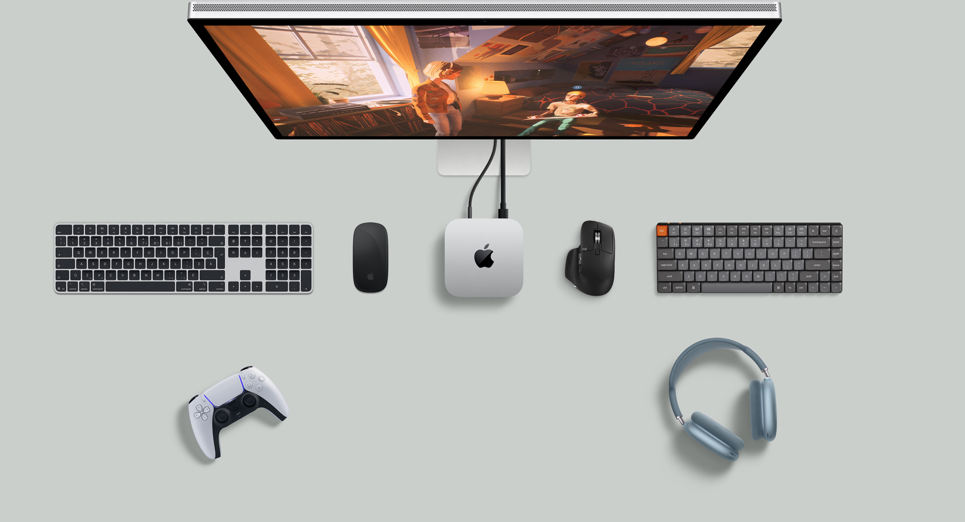 Vue du dessus d’un Mac mini argent sur un bureau avec un écran, des claviers sans fil, une souris sans fil, une manette de jeu et des AirPods Max