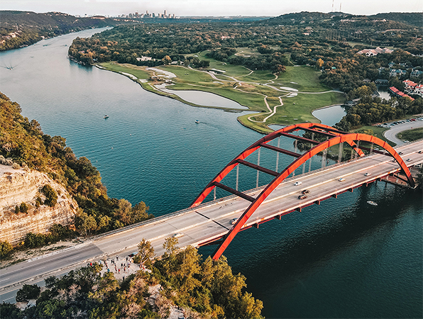 Veduta aerea di un fiume e di un ponte ad Austin, Texas, con la città sullo sfondo.