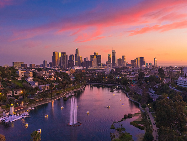 Veduta aerea di Los Angeles, con un parco e un lago in primo piano e i grattacieli della città sullo sfondo.