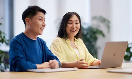 MacBook을 하나씩 앞에 두고 앉아 대화를 나누고 있는 Chris와 동료.