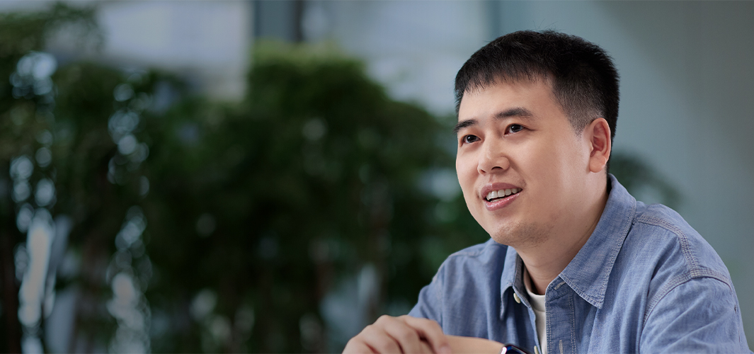 식물로 가득한 실내 공간에 앉아 있는 Ken.