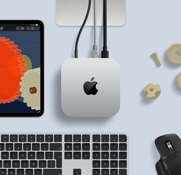 Vista desde arriba de un Mac mini color plata sobre un escritorio. Junto al Mac mini hay un teclado inalámbrico de color negro y plata, un mouse inalámbrico negro y un iPad.