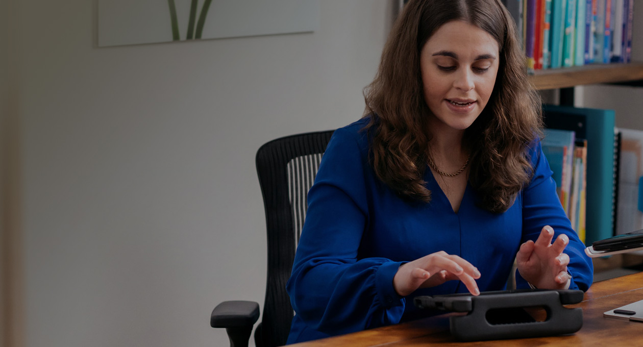 Photo de Jordyn Zimmerman, membre Apple Distinguished Educator et militante pour les personnes en situation de handicap, assise à un bureau et tapant sur l’écran d’un iPad
