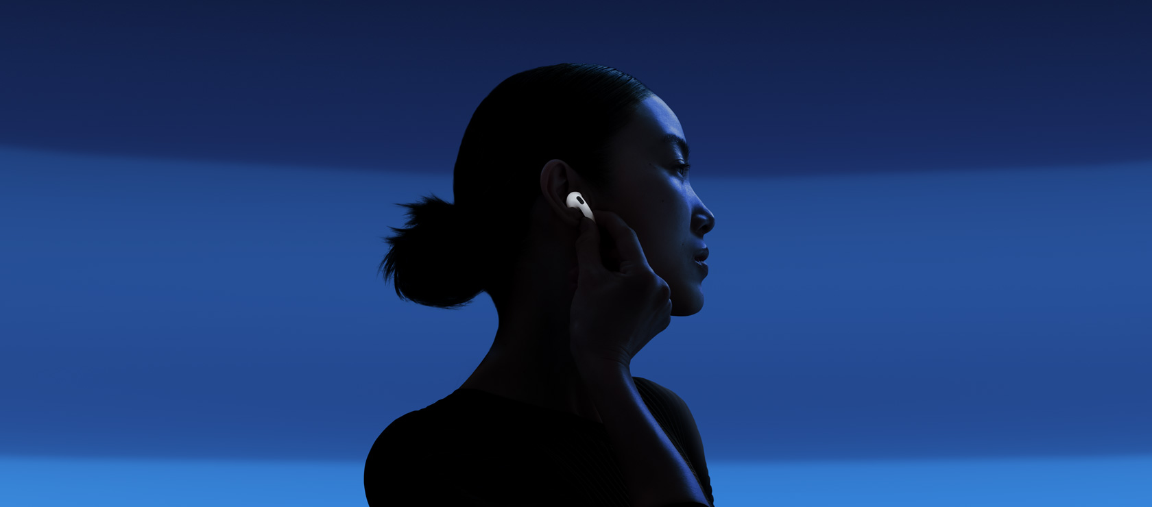 [A person enabling Active Noise Cancellation by touching the stem.]