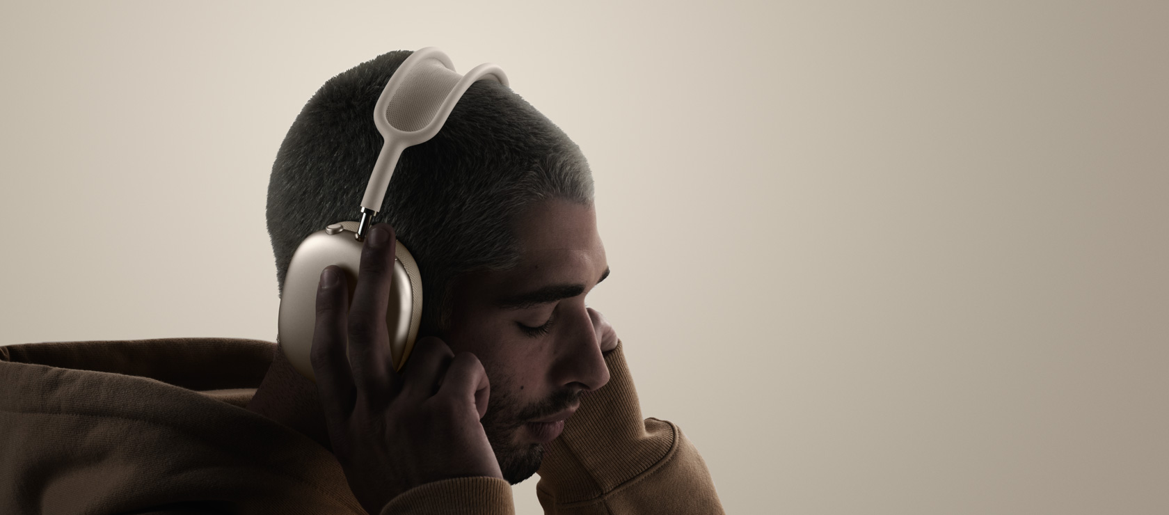 Personne portant un casque AirPods Max 2, vue latérale, touchant les coussinets