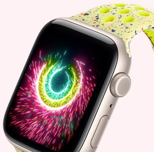 Apple Watch SE 3，展示星光色鋁金屬錶殼，活動記錄圓圈閃耀如煙火般的火花，搭配螢光綠色 Nike 運動型錶帶