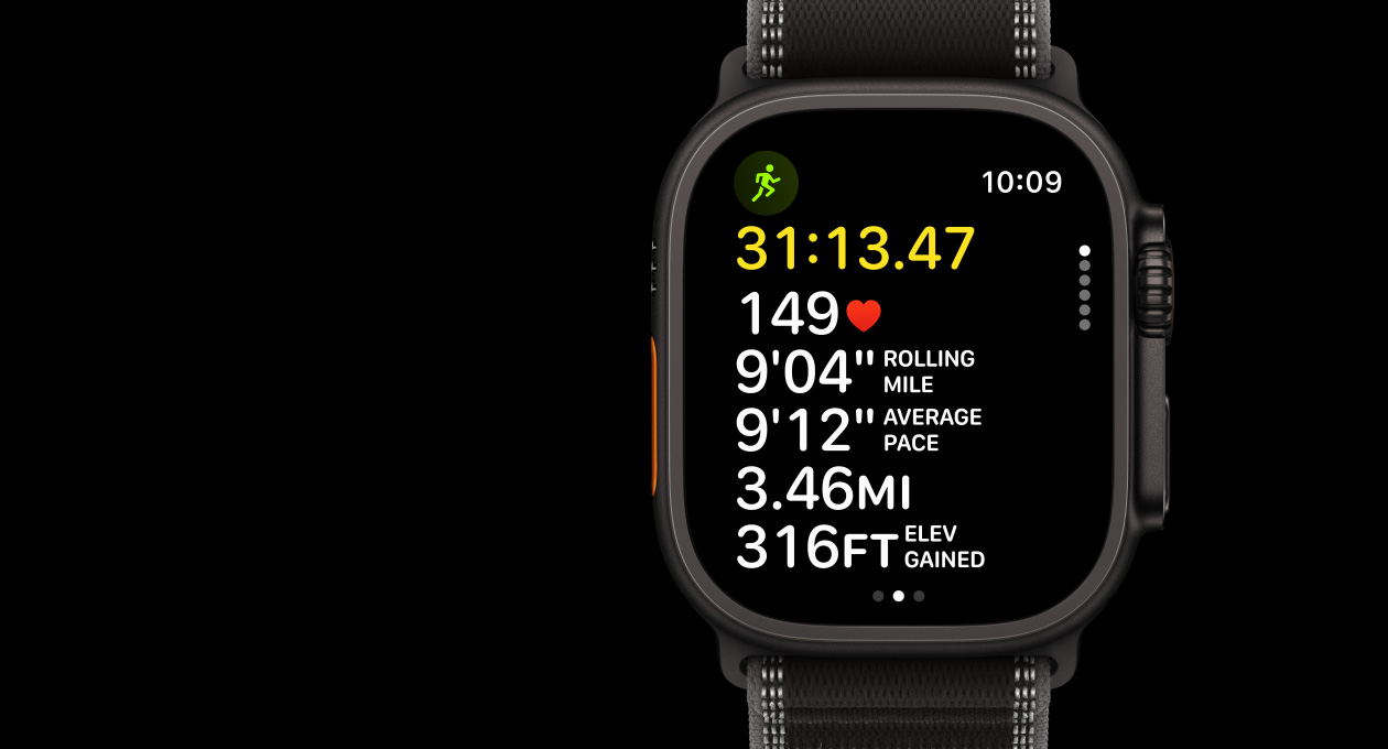 Apple Watch Ultra 3, boett i svart titan, utomhuslöpning i appen Träning, vänster utsida, snabbknapp, höger utsida, Digital Crown, sidoknapp, armband, svart/gråsvart terrängloop