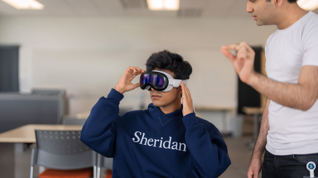 Un estudiante con una sudadera de Sheridan usa un Apple Vision Pro.
