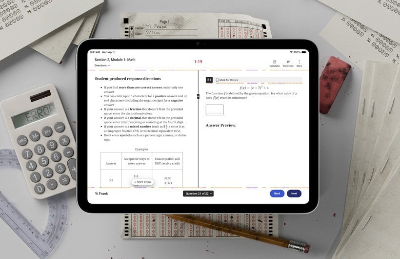 テスト用紙や文房具に混じって机の上に置かれているiPad。画面には、学力テストの数学の問題に解答するための説明が表示されている