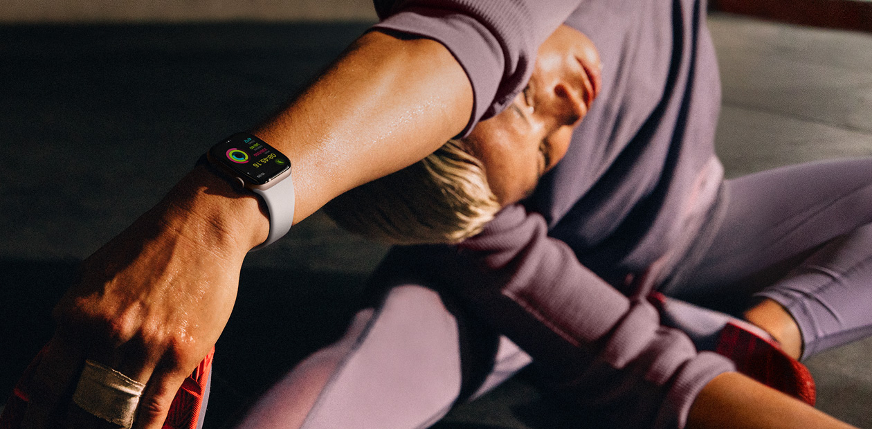 Una mujer hace estiramientos con un Apple Watch puesto.